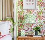 Bedroom with floral wallpaper, a lamp, and nightstand. Green and pink color scheme.