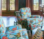 Floral patterned armchairs in a room with hardwood floors and windows.