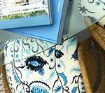Books, blue and white patterned fabric, and woven chair frame.