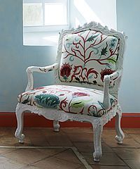 White ornate chair with floral patterned upholstery.