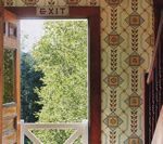 Open wooden door leads to green trees. Vintage wallpaper, exit sign above.