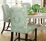 Dining room chairs with a light green pattern, set around a white table.