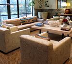 Living room with beige couches, coffee table, and large window.