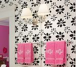 Bathroom with black flower wallpaper, pink towels, and a silver light fixture.