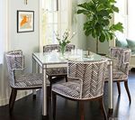 Dining room with patterned chairs, rectangular table, and a large plant.