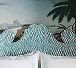Teal chevron patterned headboard against a tropical mural backdrop.