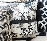 Close-up of decorative pillows in black and white. Floral and geometric patterns are visible.