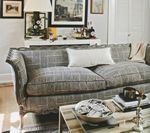 Living room with gray plaid couch, coffee table, and framed art.