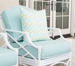 White outdoor chair with light blue cushions and a patterned pillow.