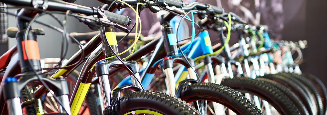 A row of bicycles are lined up on display in a store.