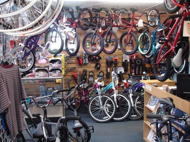A store filled with lots of bicycles hanging on the wall