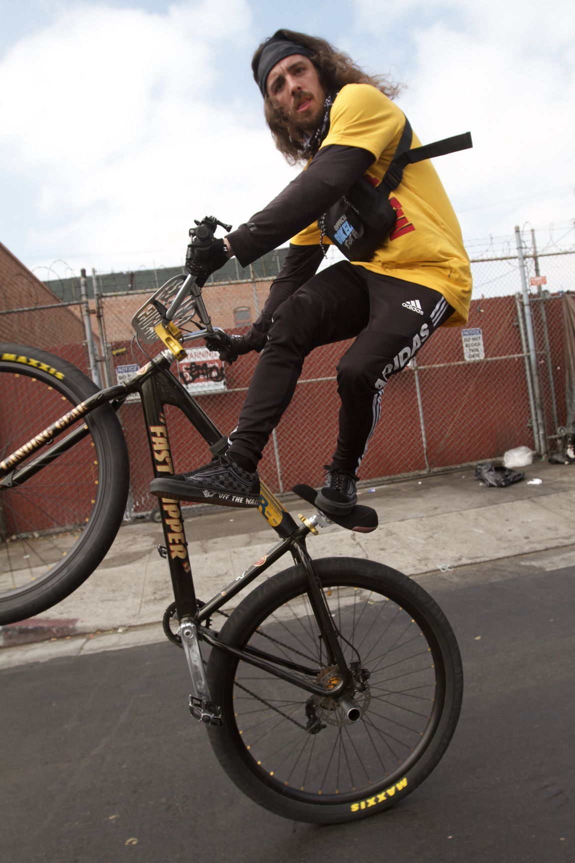 A man in a yellow shirt is riding a bike