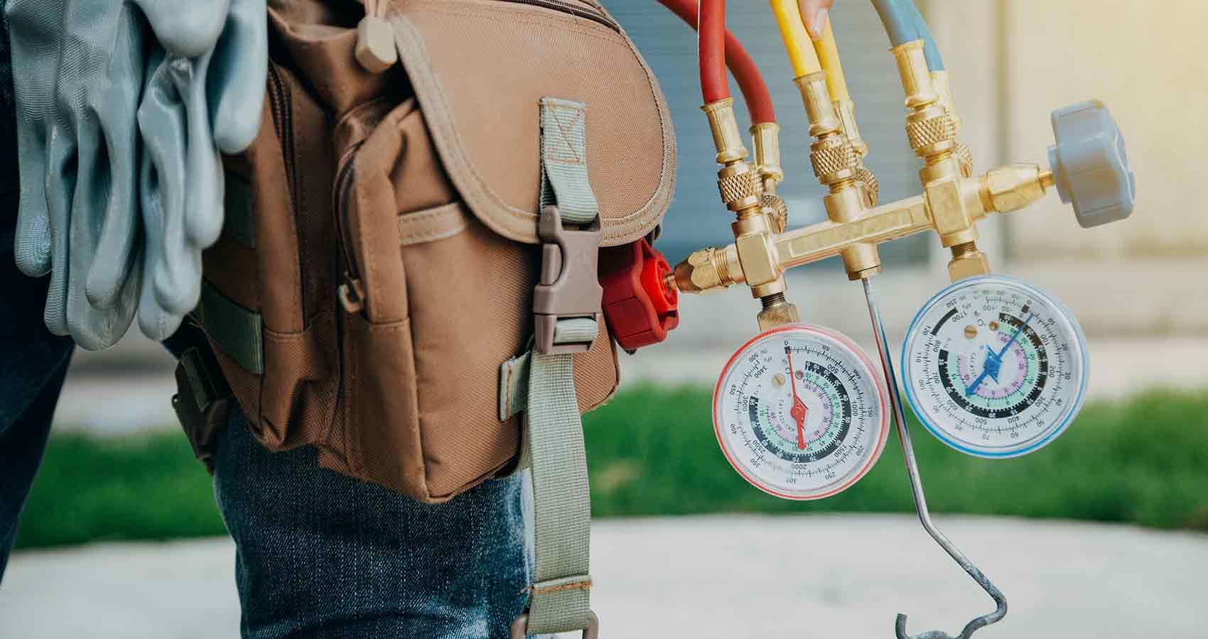 A man is carrying a backpack and a bunch of tools.