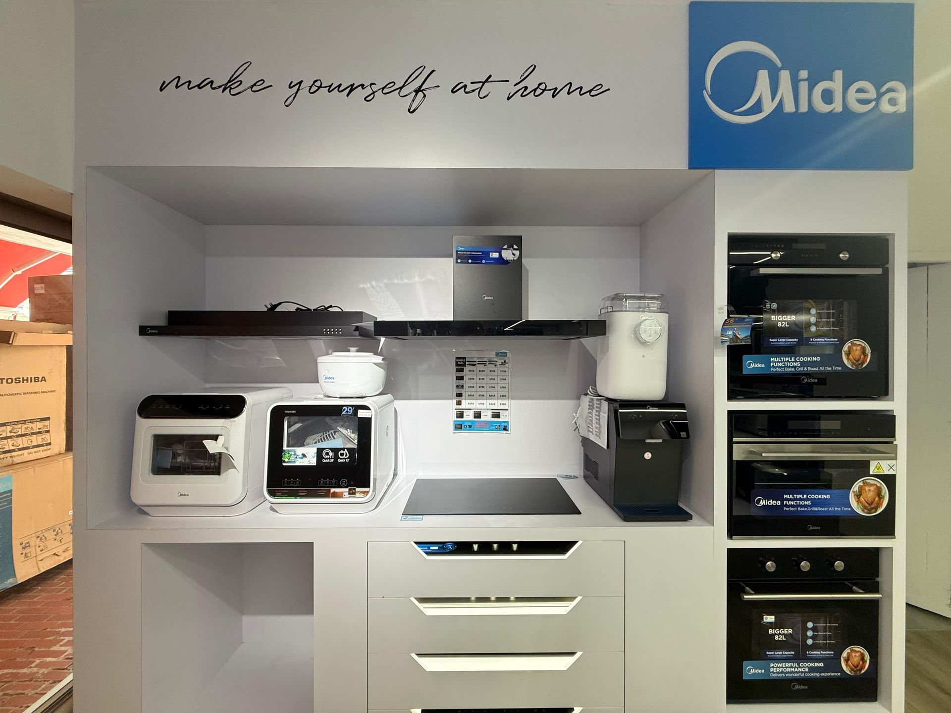 A kitchen with a lot of appliances and a sign that says `` make yourself at home ''.