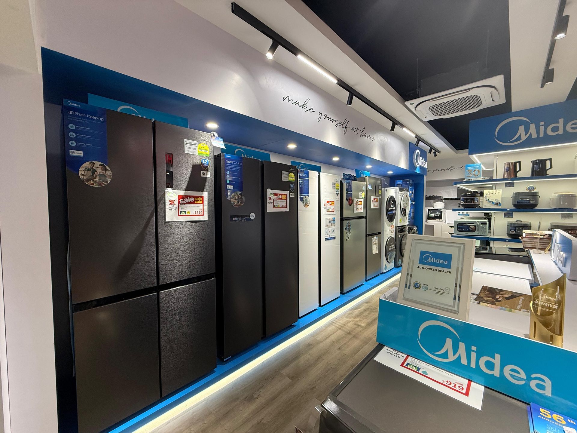 A row of refrigerators are lined up in a store.