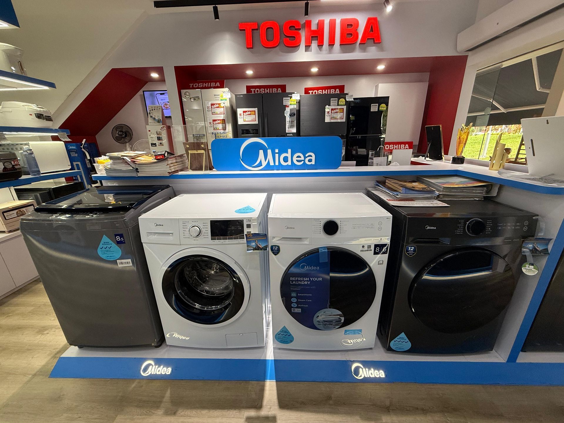 A display of washing machines and dryers in a store.