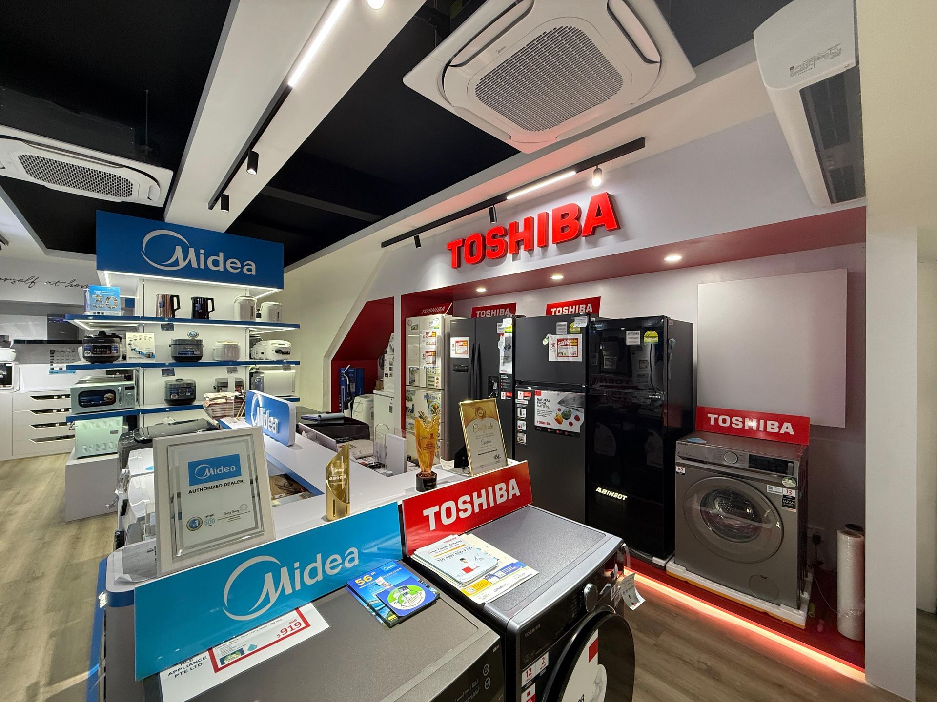 A store filled with lots of appliances including a refrigerator and a washing machine.