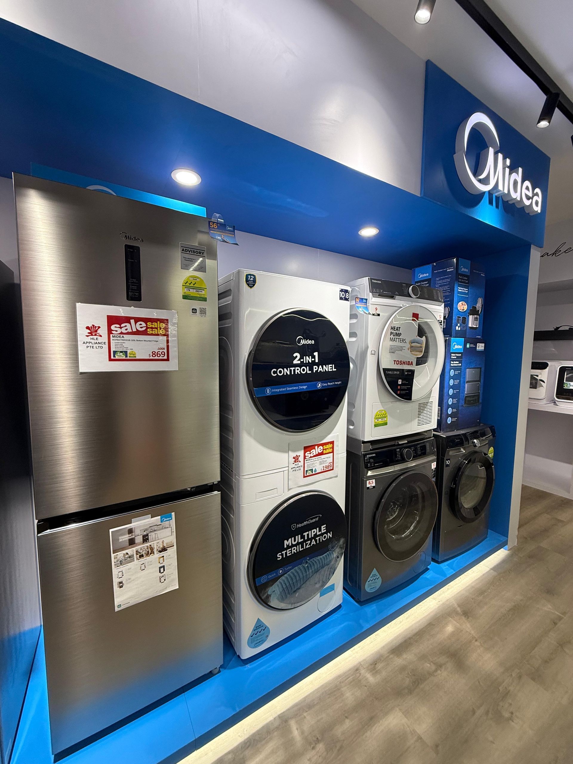A display of refrigerators , washers and dryers in a store.