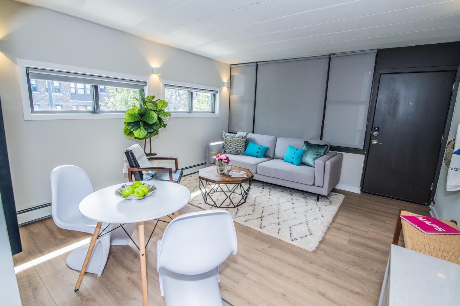 A living room with a couch , table and chairs.