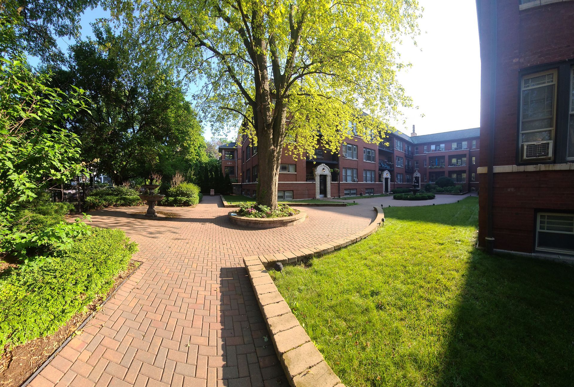 A brick walkway leading to a large brick building
