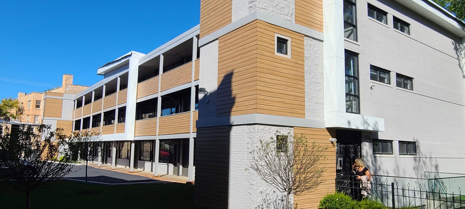 A large brick building with a lot of windows and a blue sky in the background.