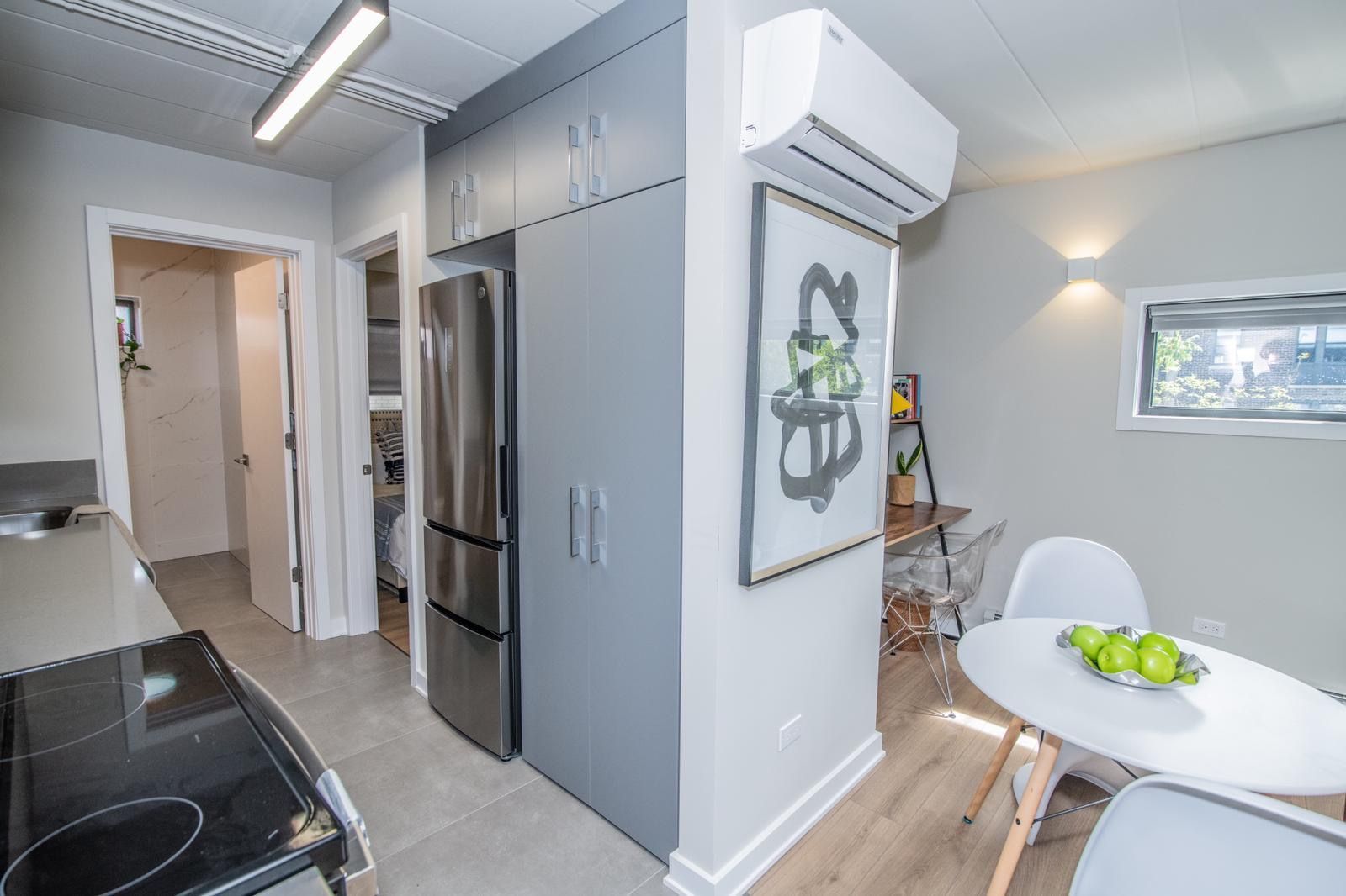 A kitchen with a refrigerator , stove , table and chairs.