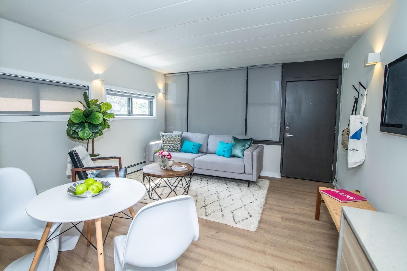 A living room with a couch , table , chairs and a television.