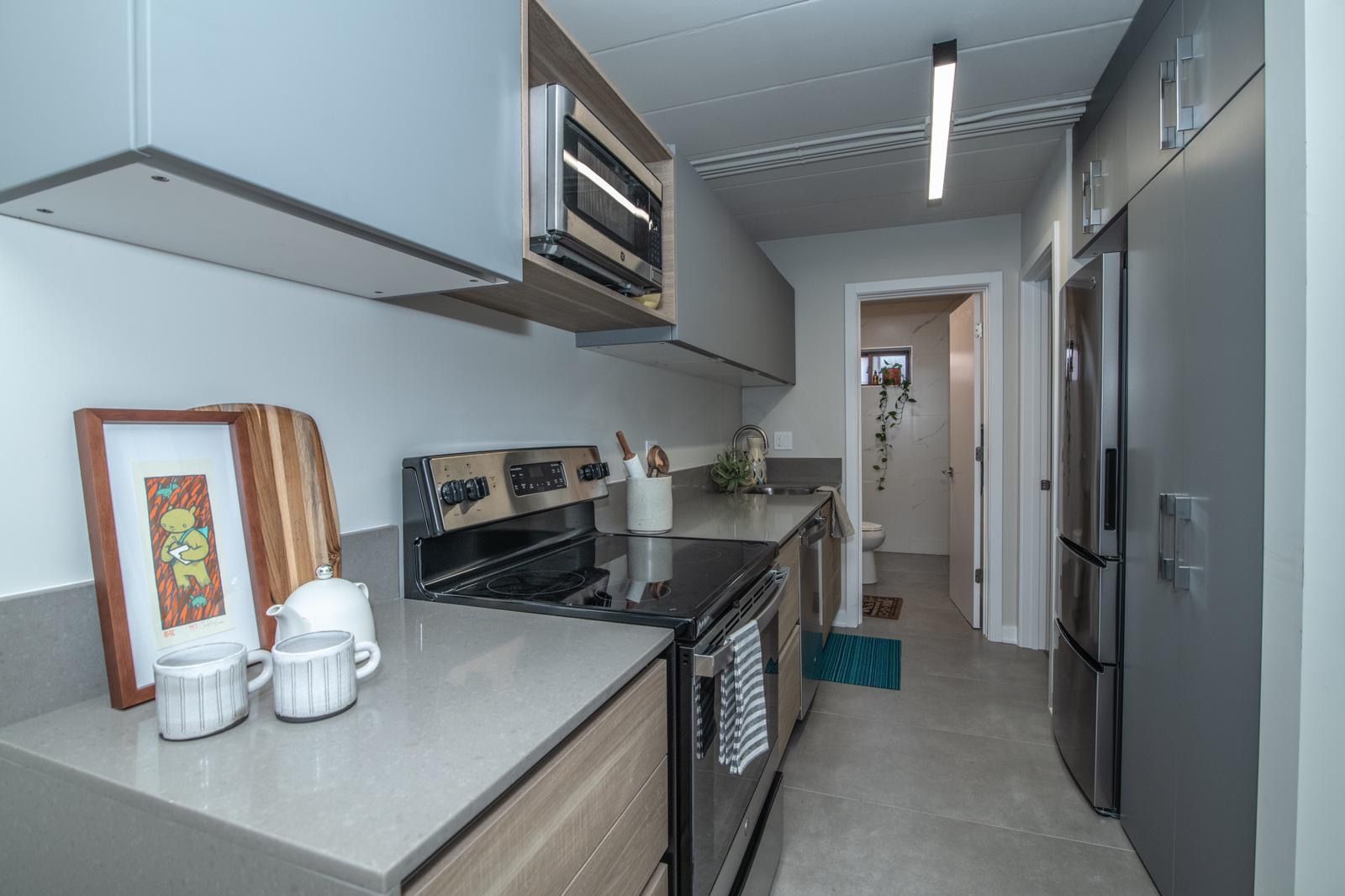 A kitchen with a stove , refrigerator , and microwave.