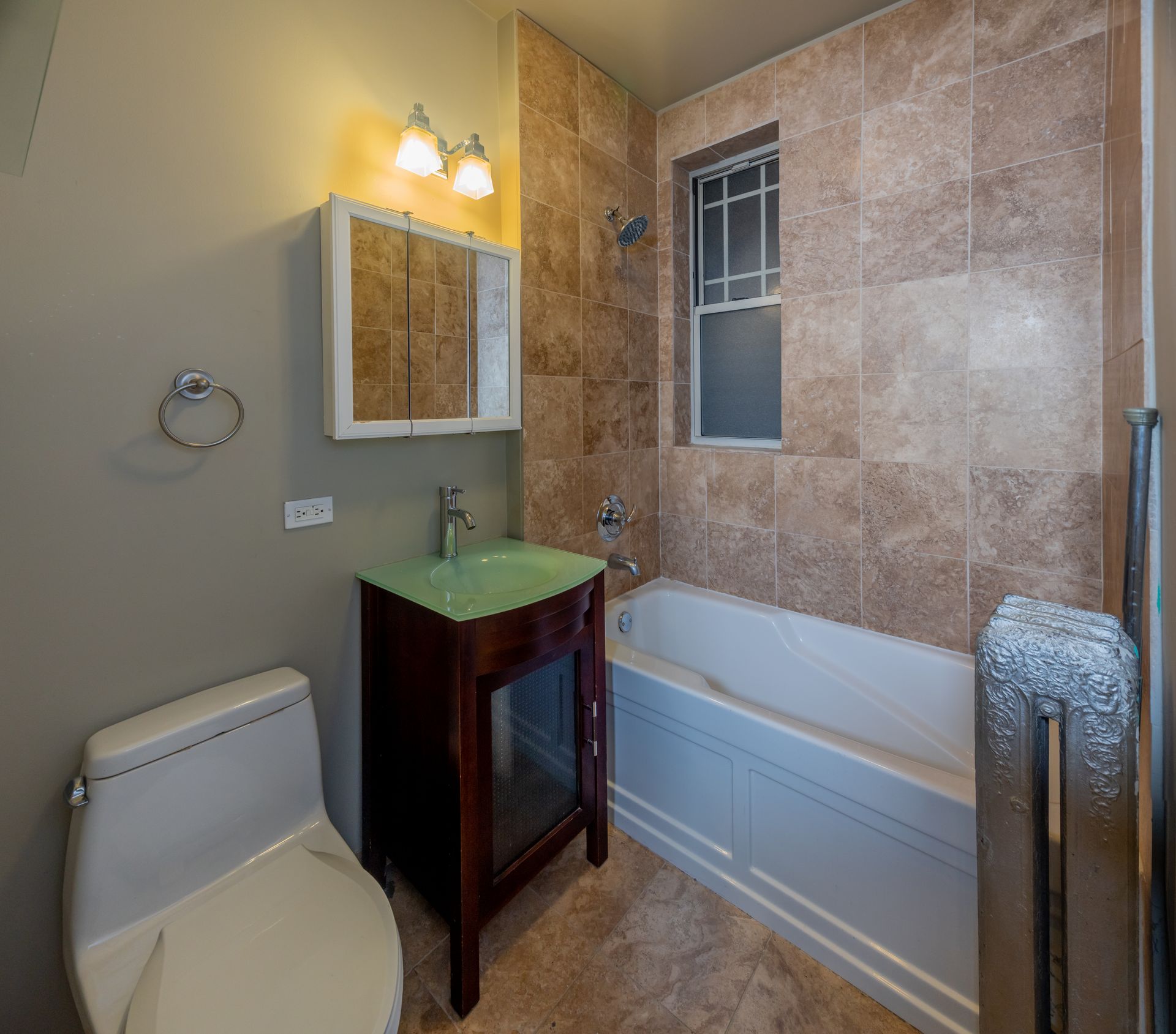 A bathroom with a toilet , sink , and bathtub.