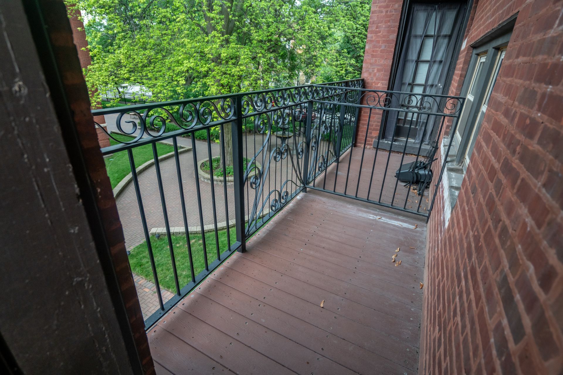 A balcony with a wrought iron railing on a brick building.