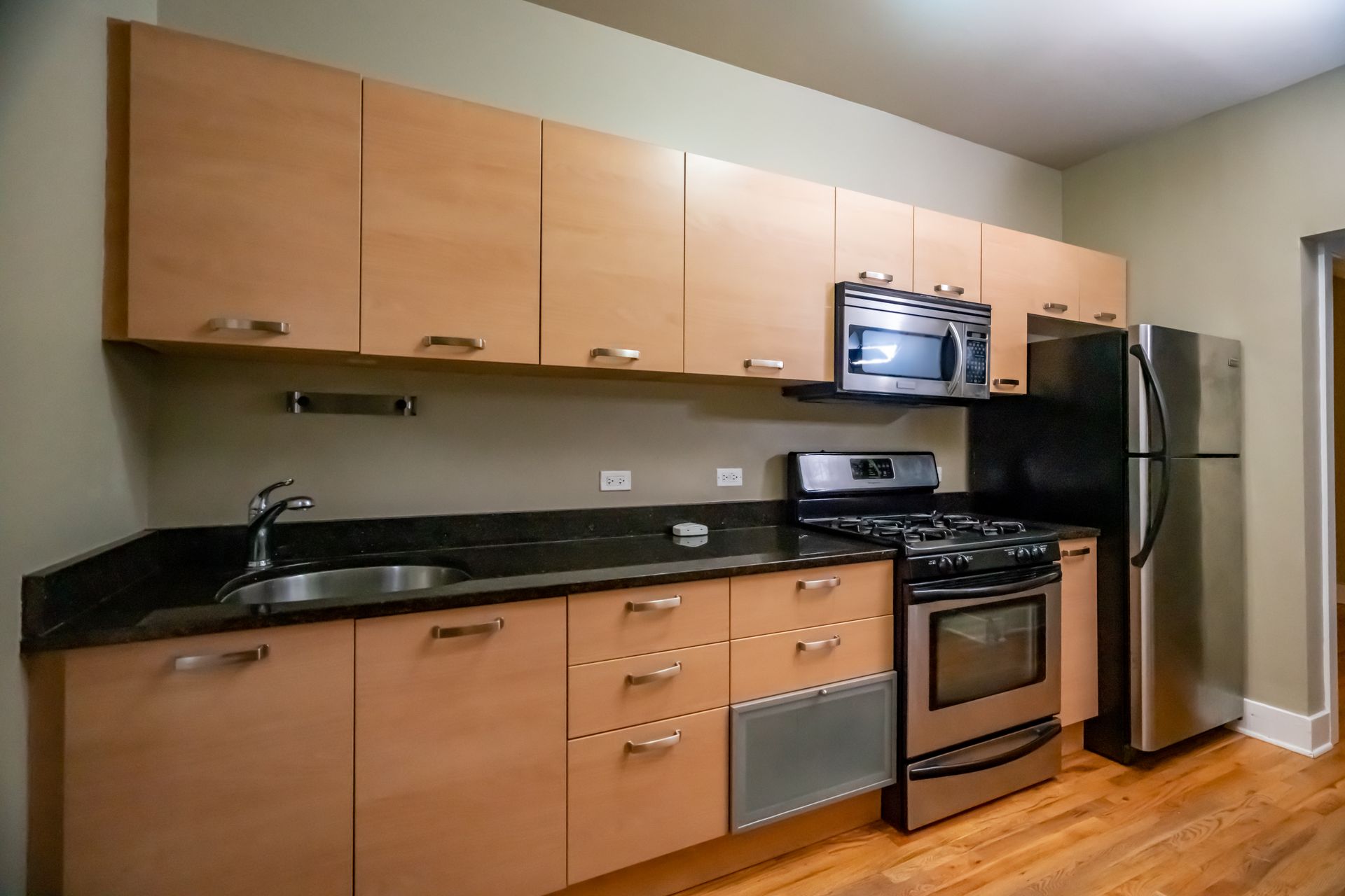 A kitchen with stainless steel appliances and wooden cabinets