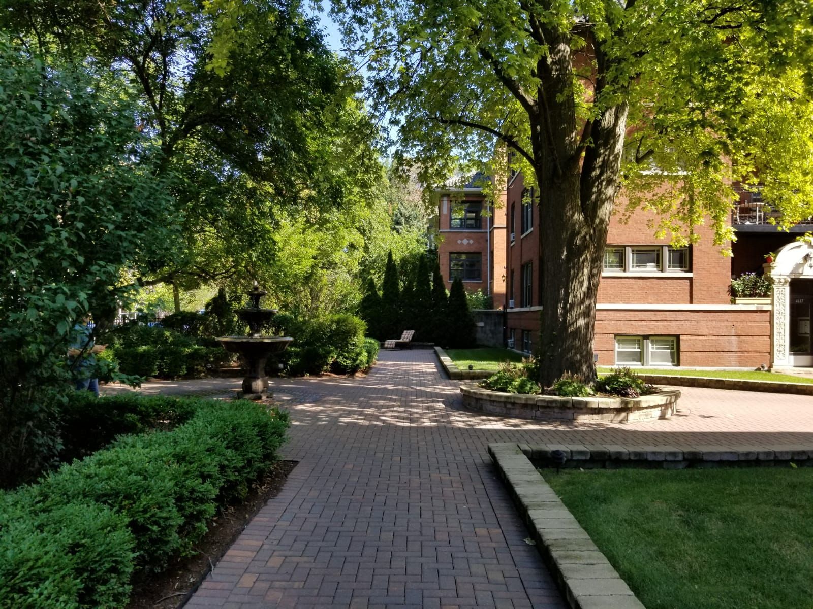 A brick walkway leads to a large brick building