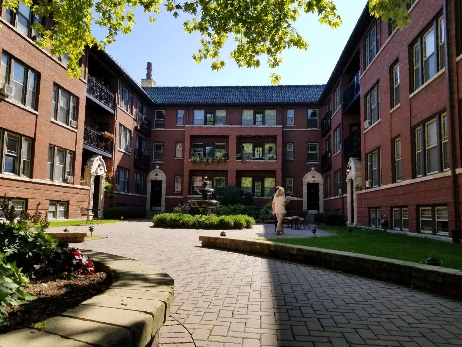 A brick building with a courtyard in front of it