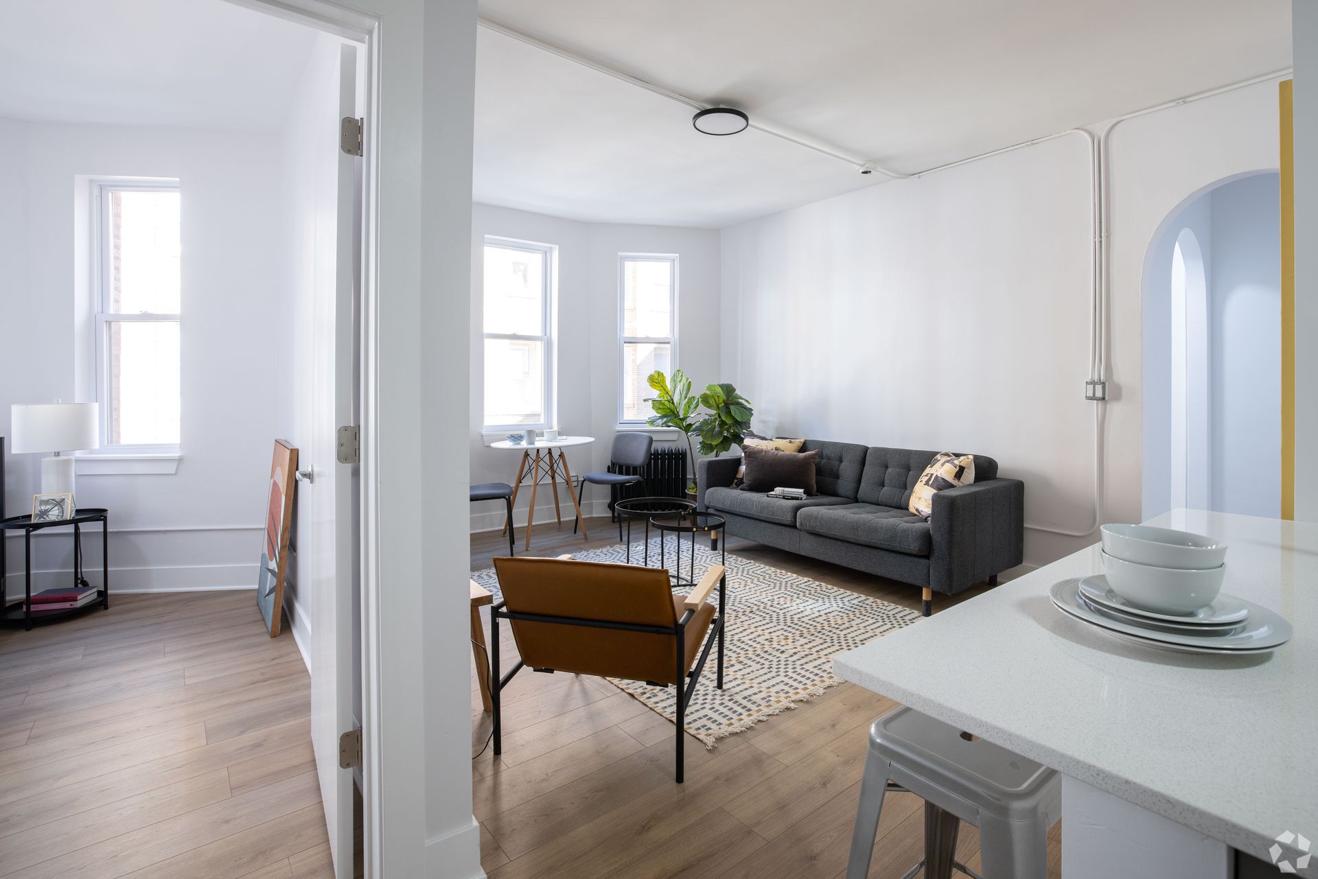 A living room with a couch , chair , table and window.