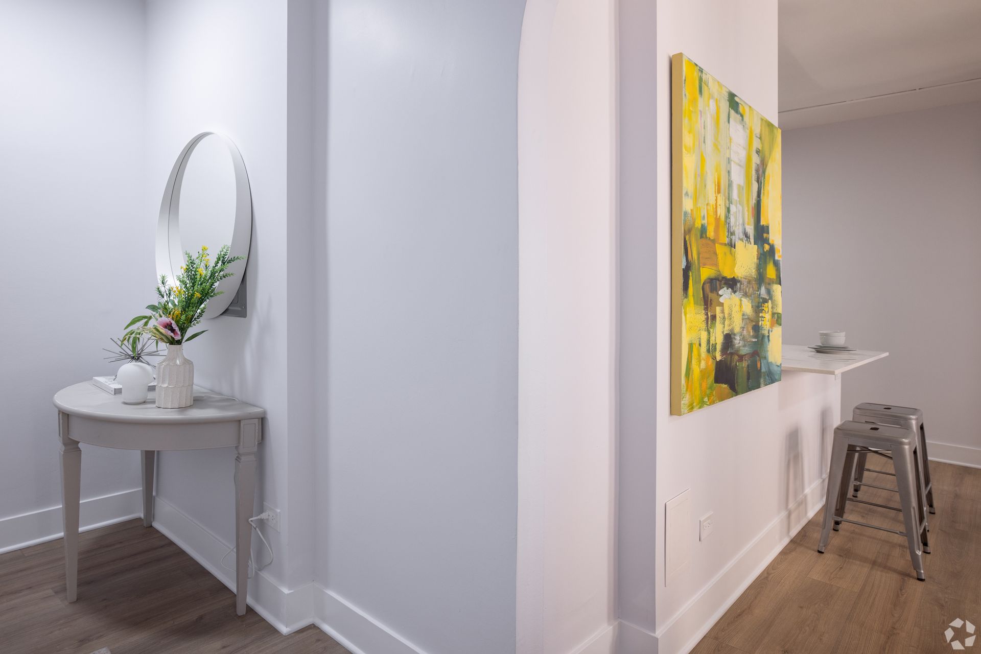 A hallway with a table and a painting on the wall.