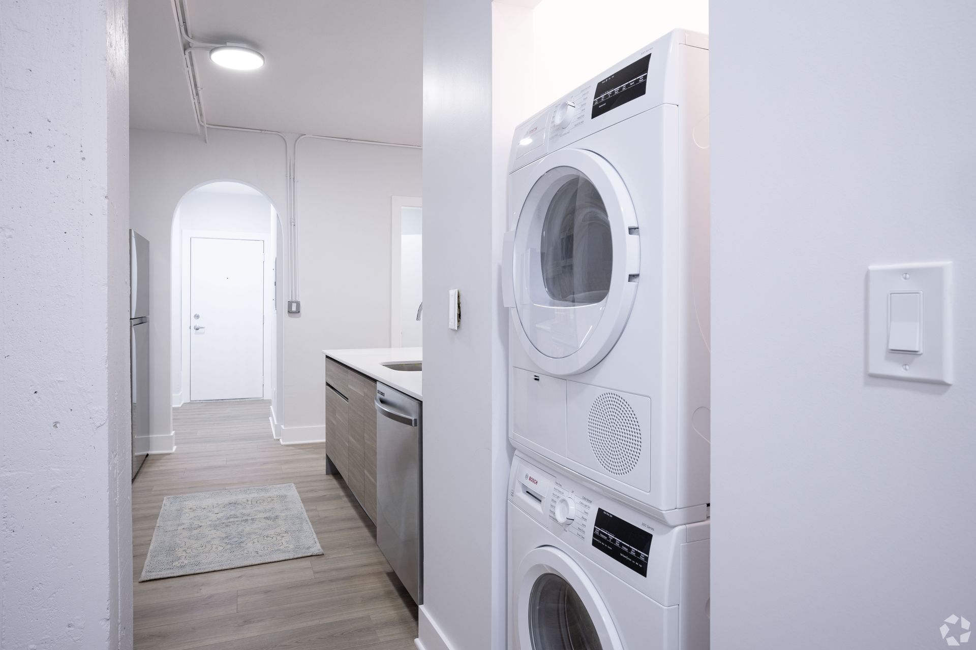 A washer and dryer are stacked on top of each other in a laundry room.