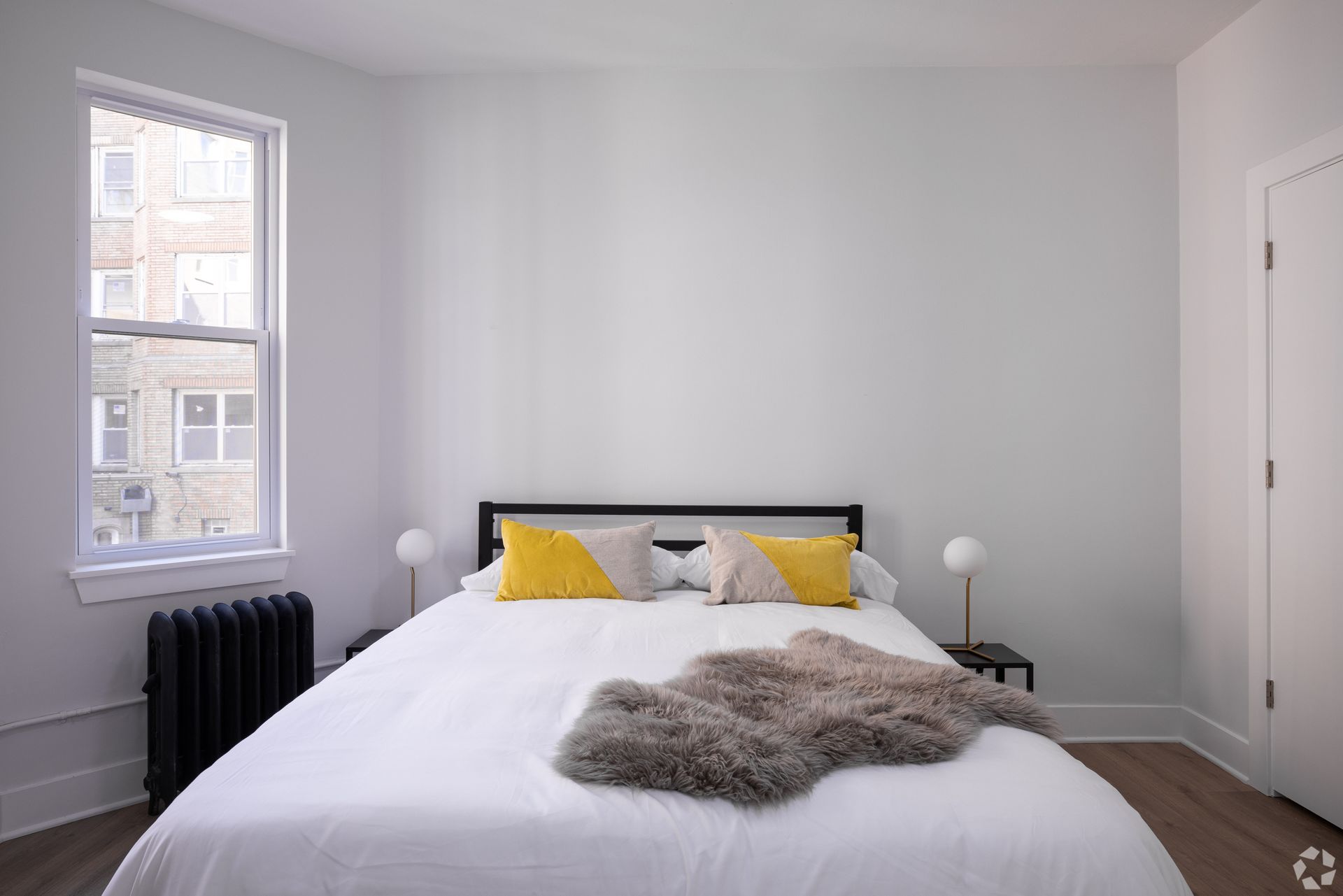 A bedroom with a large bed and a window.