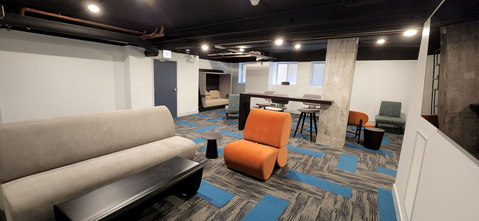 A living room with a couch , chairs , and tables.