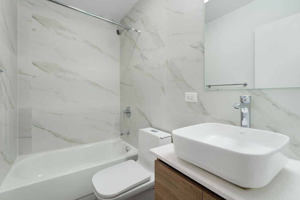 A bathroom with a sink , toilet , bathtub and mirror.