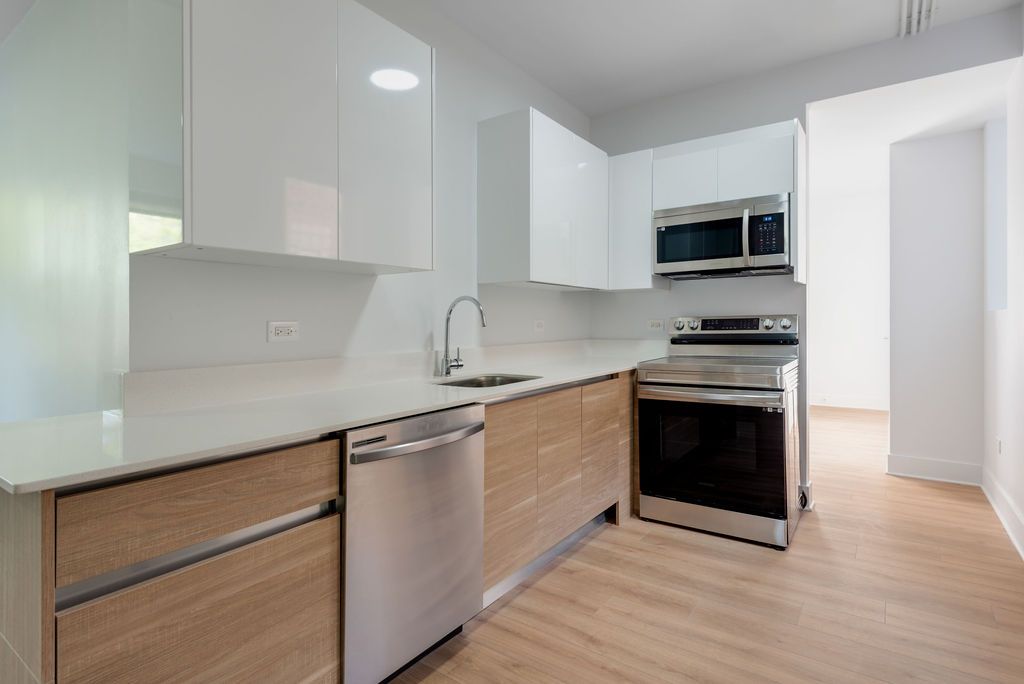 A kitchen with stainless steel appliances and wooden cabinets.