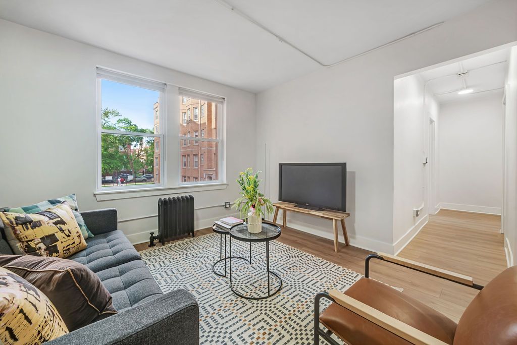 A living room with a couch , chair , table and television.