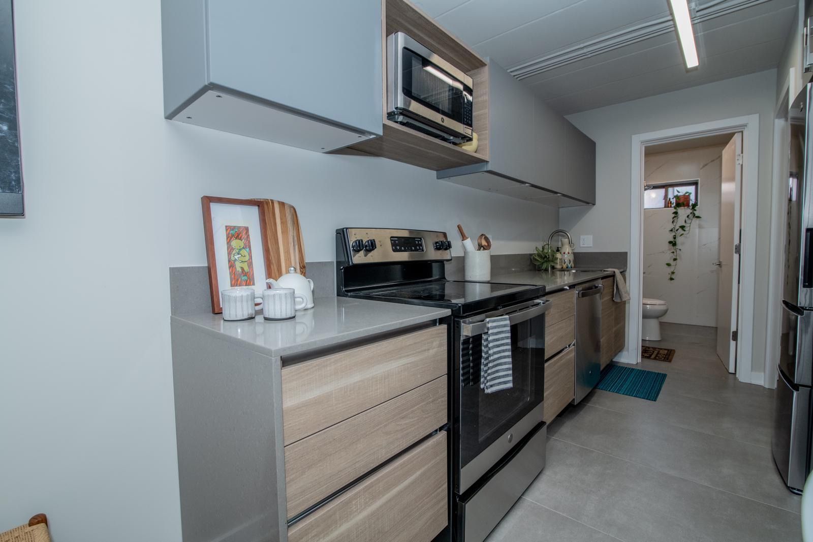 A kitchen with stainless steel appliances and wooden cabinets.