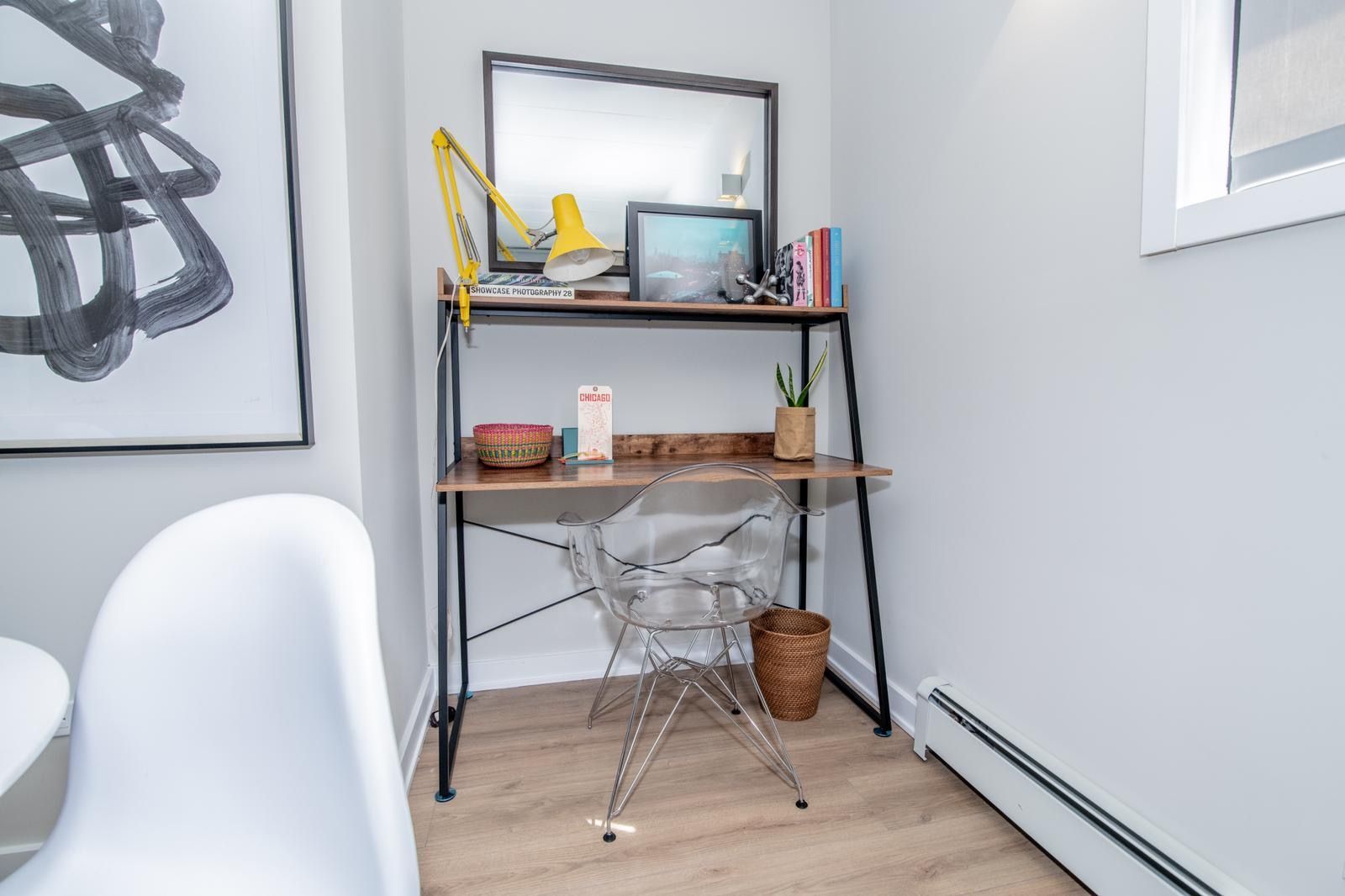 A small desk with a chair in a corner of a room.