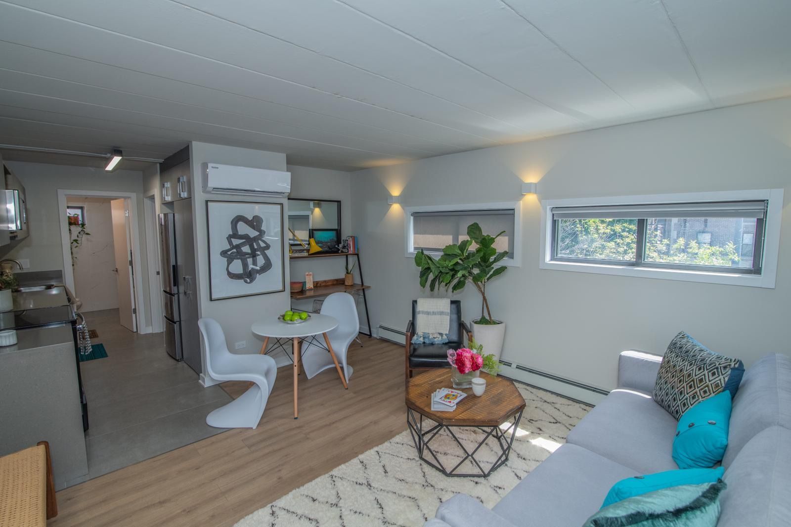 A living room with a couch , table and chairs
