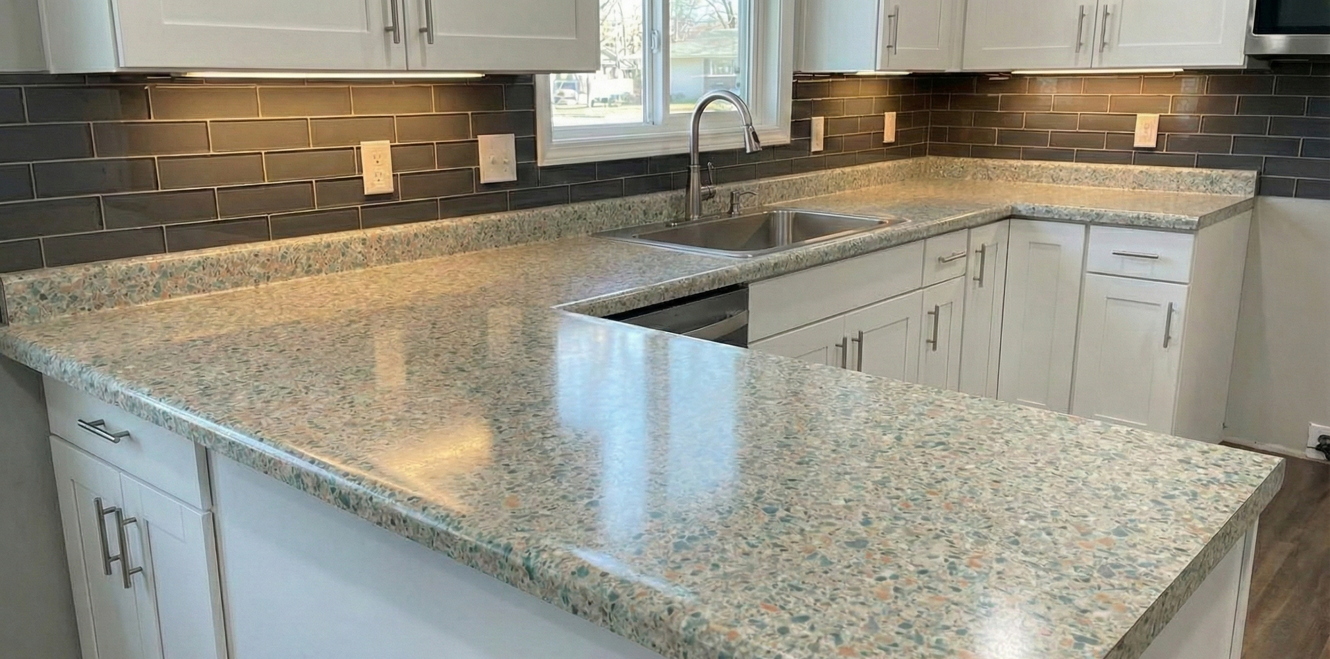 Kitchen with white cabinets, gray granite countertops, and dark gray backsplash.