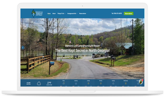 Laptop screen displaying a website: A road leading to a lake in North Georgia, website logo at top.
