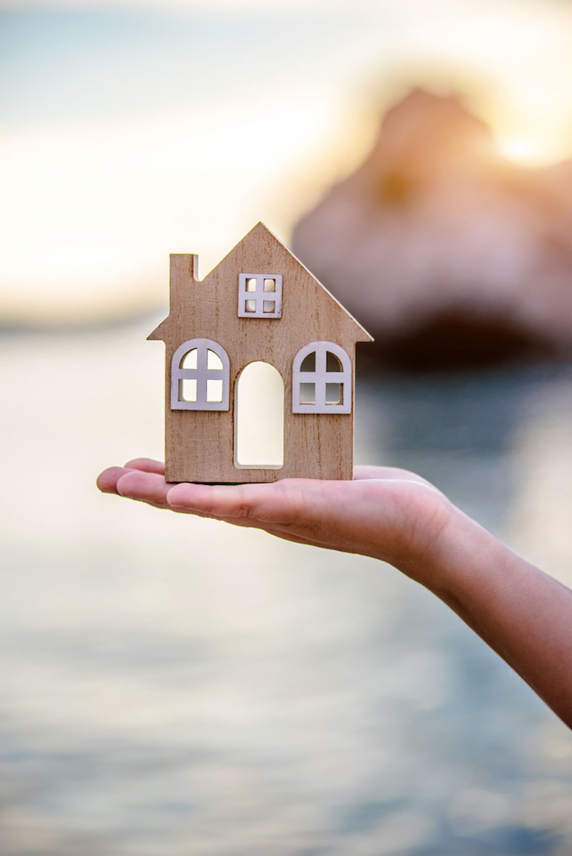 A Person Is Holding a Small Wooden House in Their Hand — Cairns Property Collective in Edmonton, QLD