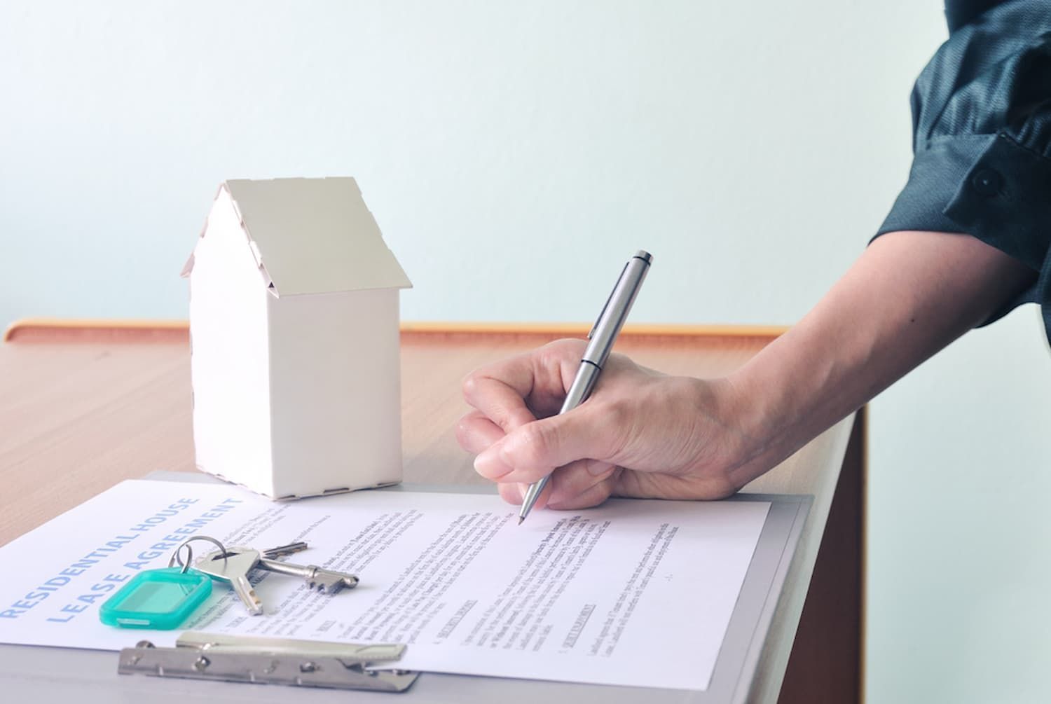 A Person Is Writing on A Piece of Paper with A Pen — Cairns Property Collective in Edmonton, QLD