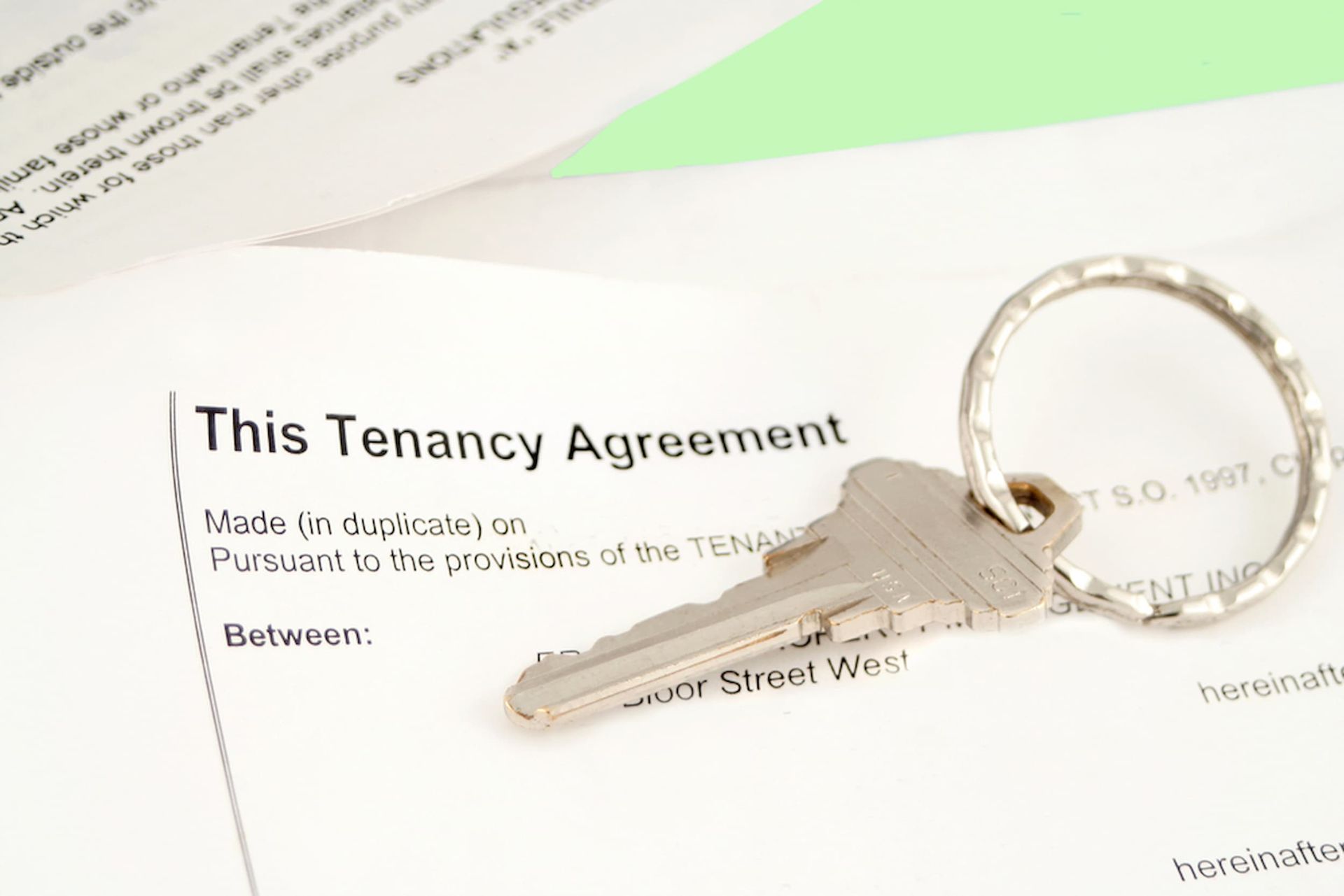 A Key Is Sitting on Top of A Tenancy Agreement — Cairns Property Collective in Redlynch, QLD