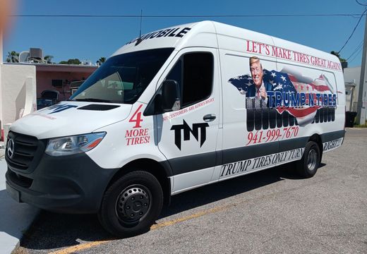 A white van with the word tnt on the side is parked in a parking lot.